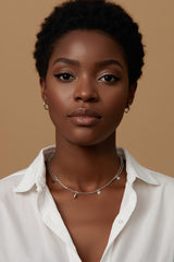 Woman with short hair wearing CharmFlip silver charm necklace over a white shirt