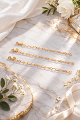 CharmFlip 18K gold PVD extension chain, 12 inch, laid flat on marble with white flowers