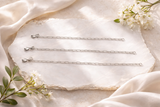 CharmFlip sterling silver extension chain, 12 inch, laid flat on marble with white flowers